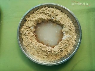香油豆沙馅绿豆糕,在绿豆粉上面挖个小坑,将白糖、凉白开放入;