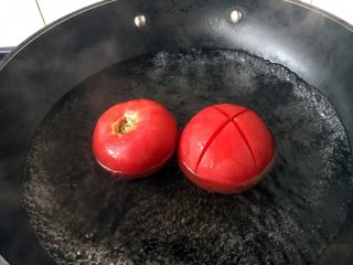 孩子爱吃的西红柿鸡蛋打卤面,水开后放入西红柿,正反两面都要烫30秒左右,这样容易剥皮。