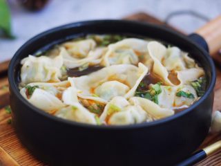 荠菜鸡肉馄饨,往汤碗里倒入煮小云吞的汤,用汤勺搅动一下碗里的汤,香菜、冬菜、小虾皮被滚汤烫熟,最后盛入小云吞即可。