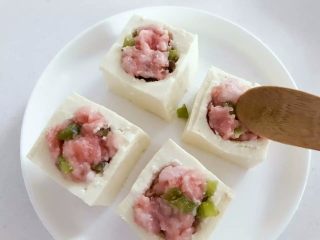 宝宝辅食：豆腐箱（肉末酿豆腐）,把步骤2中备好的猪肉糜填入，和豆腐块表面平齐稍稍多出一点点即可。